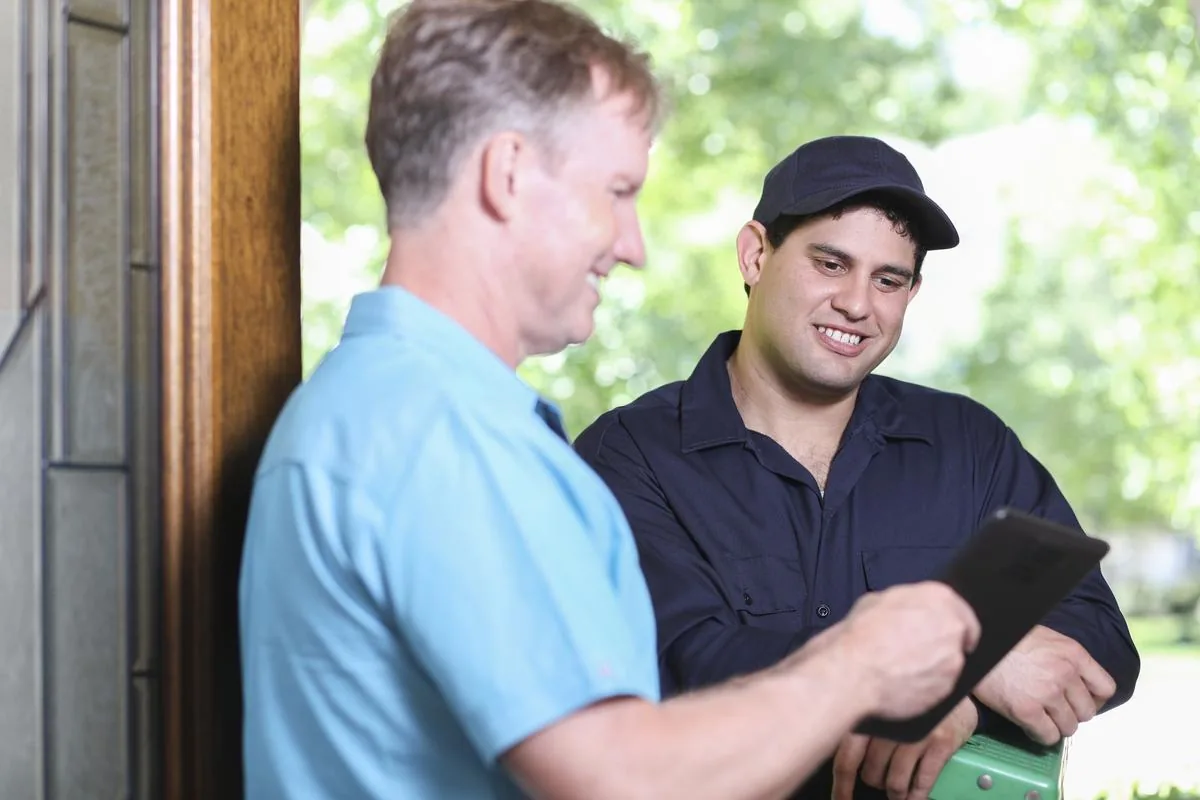 Quickill technician reviewing service details with homeowner at front door